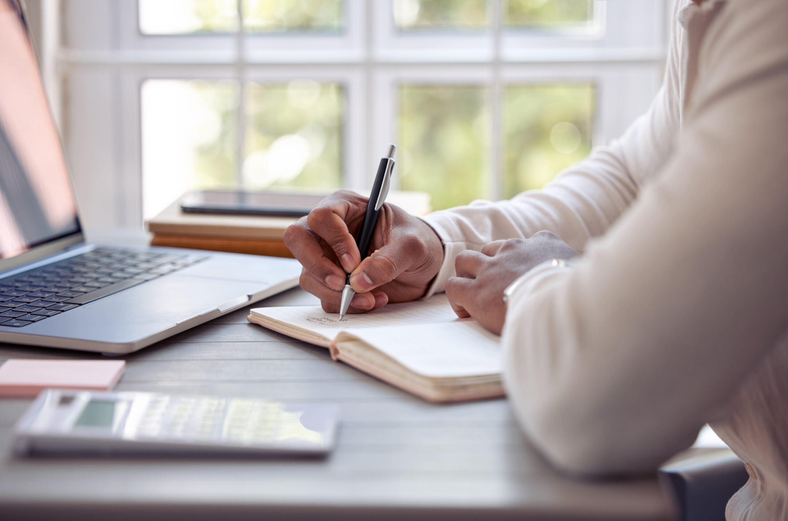 shot of an unrecognizable male writing in his diary at home.
